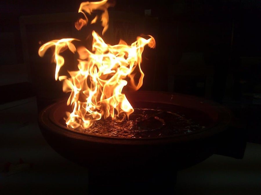 A gas fire pit burning in a round bowl